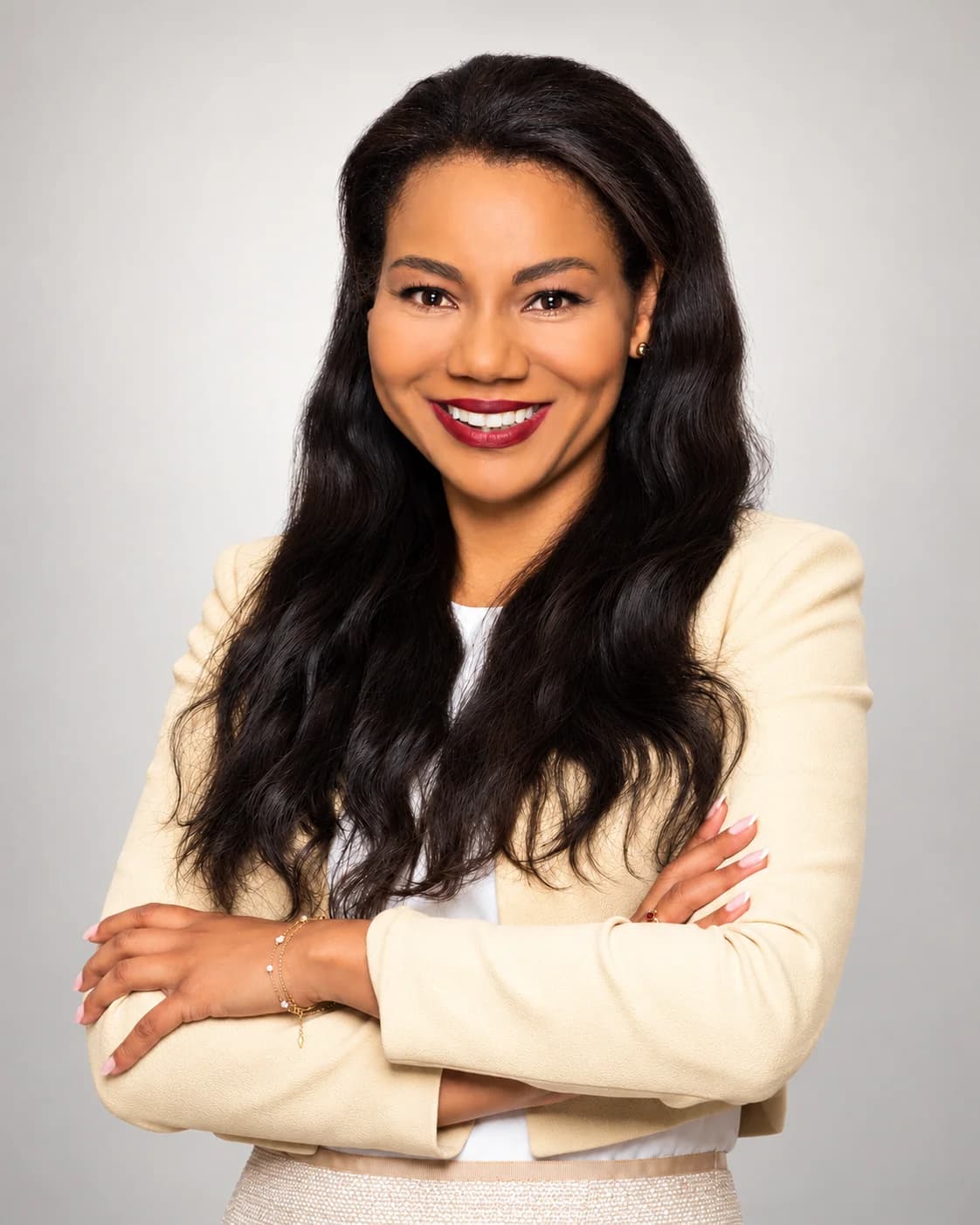 Victoria Igbauboa, Founder and Lead Advisor of IGNOVA GLOBAL, smiling in a cream blazer against a neutral studio background.